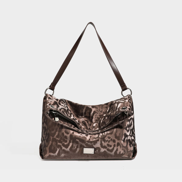 Lässig fallende Hobo-Schultertasche mit Leopardenprint, glänzender satinähnlicher Oberfläche, silberfarbenen Ringbeschlägen und schmalem Schulterriemen