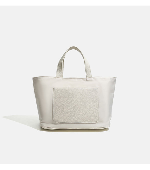 Structured lightweight nylon tote bag with textured double top handles and snap-button front detail, detail view 11