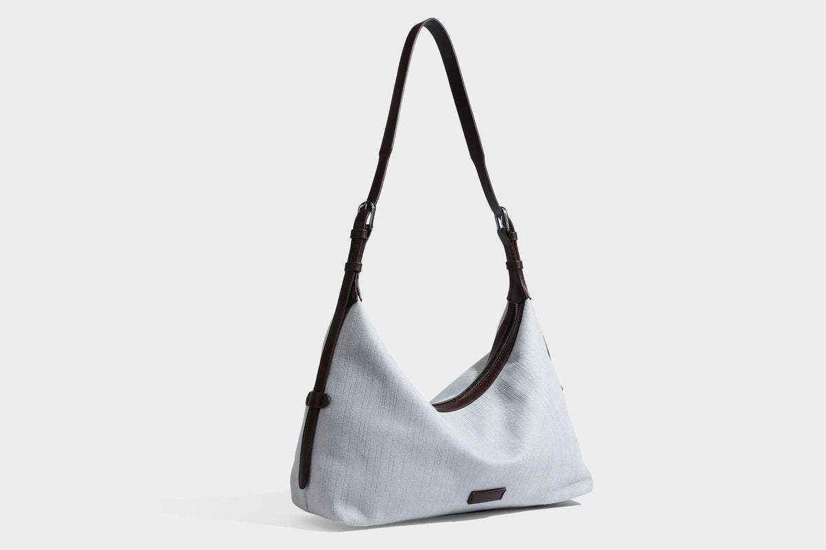 Slouchy olive green canvas hobo shoulder bag with black leather-look trim, zip-top closure, and adjustable strap, detail view