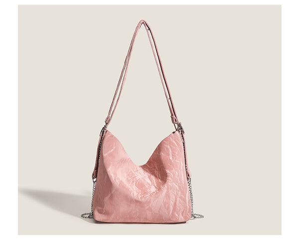 Blush pink slouchy hobo bag with crinkled sheen finish, silver-tone chain hardware, and adjustable shoulder strap, detail