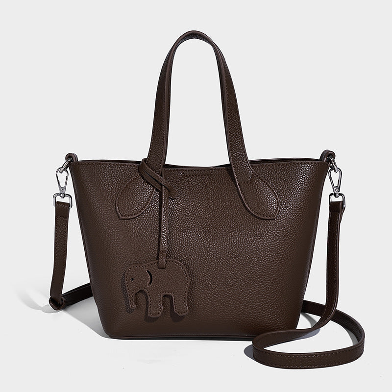 Compact pebbled bucket tote bag with elephant charm, twin top handles, and detachable crossbody strap, detail view 3