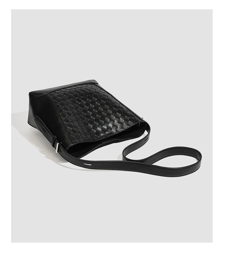 Large black bucket shoulder bag with diamond woven leather-look front panel, smooth side panels, magnetic snap closure, and