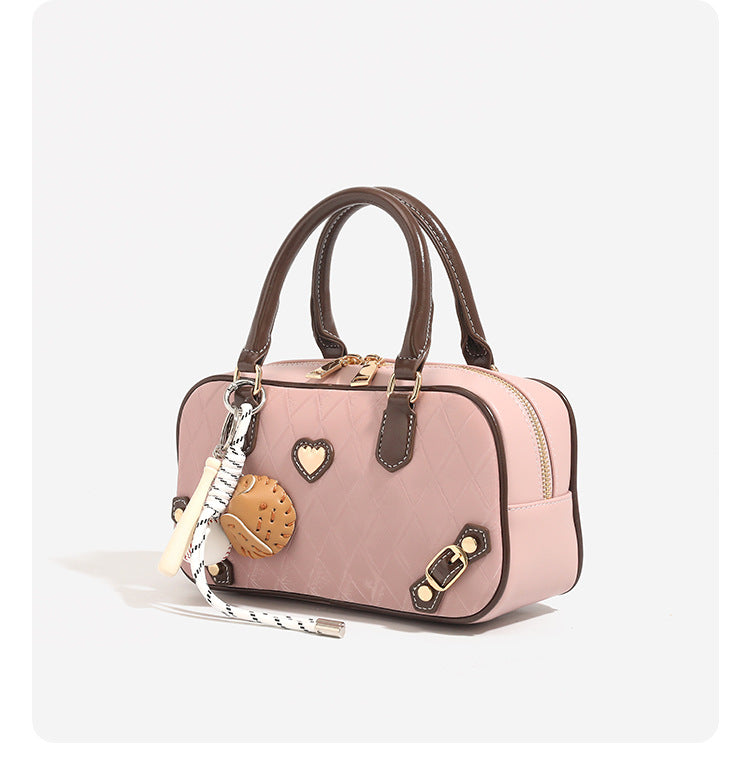 Small structured blush pink quilted diamond Boston barrel bag with brown leather-look trim, double top handles, heart accent