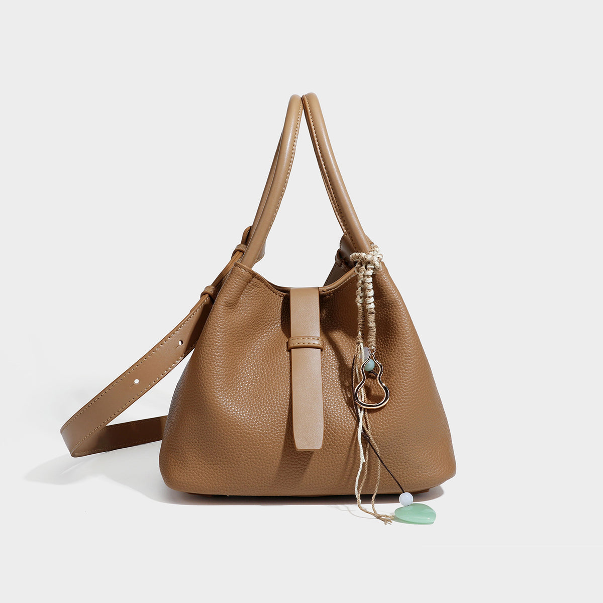 Pebbled leather-look bucket tote bag with rolled double handles, drawstring closure, braided cord charm, and detachable