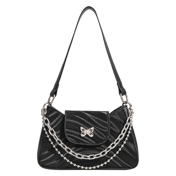 Small trapezoid shoulder bag with ripple leather-look finish, silver butterfly front clasp, and layered chain-and-ball strap