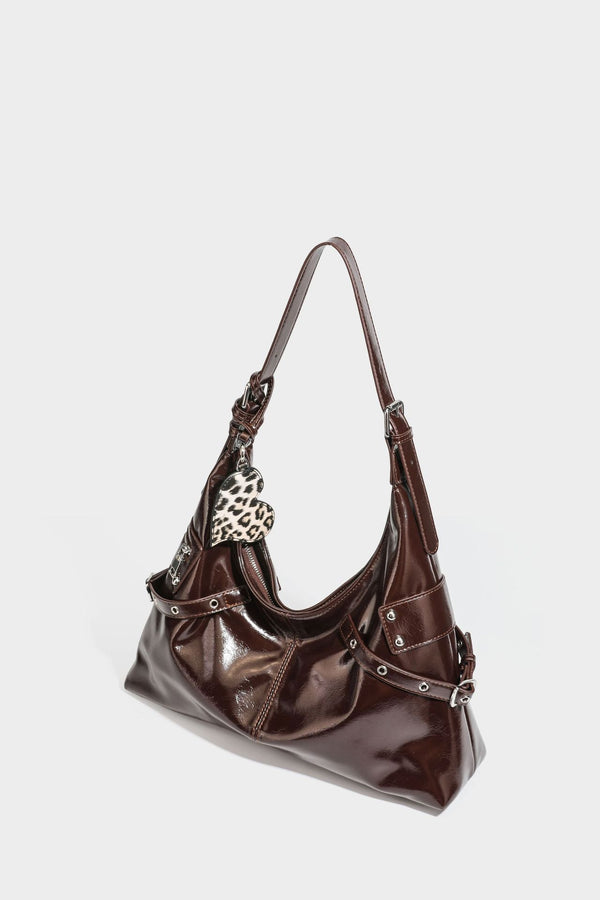Glänzende dunkelbraune, lässig geschnittene Hobo-Schultertasche mit Riemendetail mit silberfarbenen Ösen, Reißverschlussfach auf der Vorderseite und Herz mit Leopardenmuster