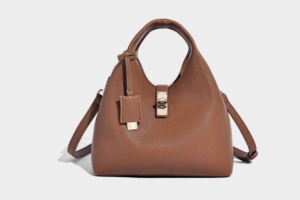 Structured pebbled-texture bucket bag with arched top handles, gold-tone turn-lock closure, and detachable shoulder strap