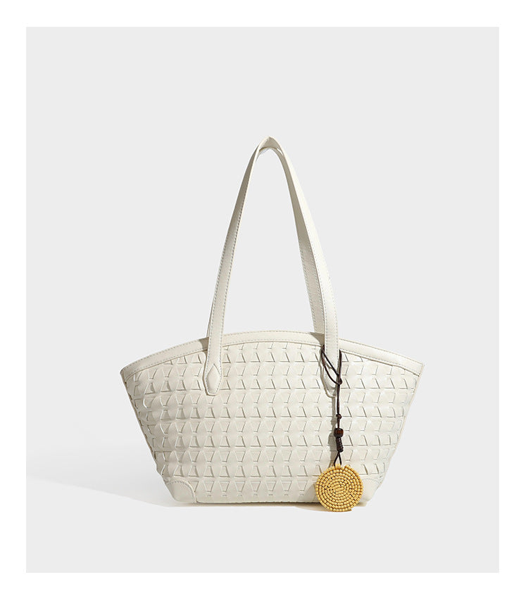 Large leather-look tote bag with geometric woven emboss, double shoulder straps, and round woven cord charm in brown, detail