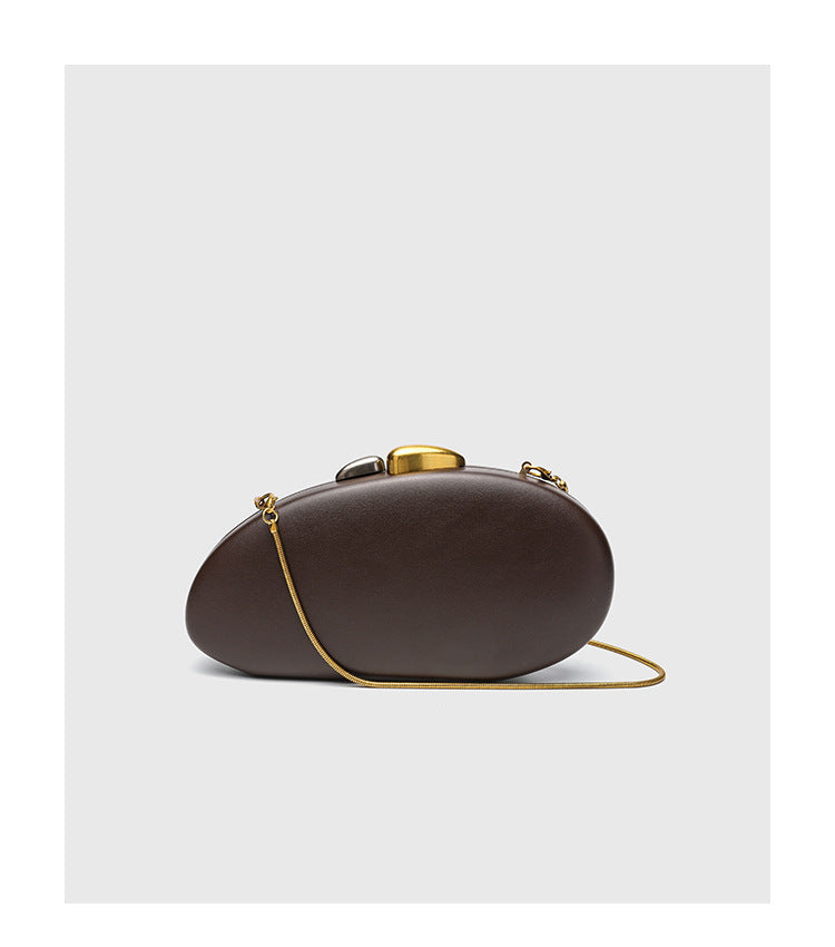 Oval hard-shell crossbody clutch bag with smooth matte leather-look finish and gold-tone snake chain strap, detail view 11