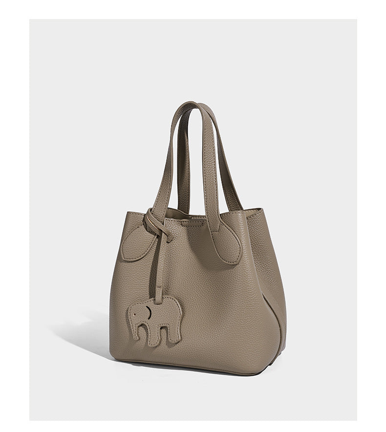 Compact pebbled bucket tote bag with elephant charm, twin top handles, and detachable crossbody strap, detail view 9
