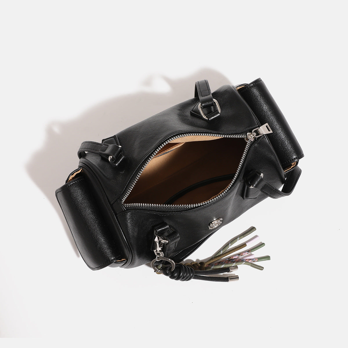 Schwarze Bowling-Schultertasche in glänzender Lederoptik mit zwei Trägern, silberfarbenen Beschlägen, seitlichen Klappentaschen und geflochtener Kordel