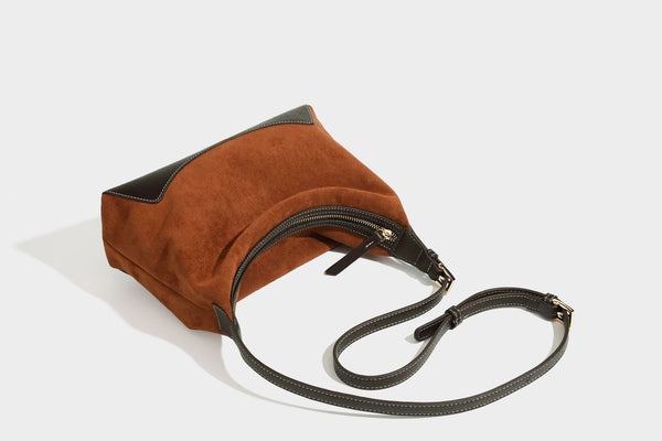 Lässig fallende Hobo-Schultertasche in warmem Braun mit dunkler Kontrastverzierung in Lederoptik, geschwungenem Reißverschluss und langem, detail