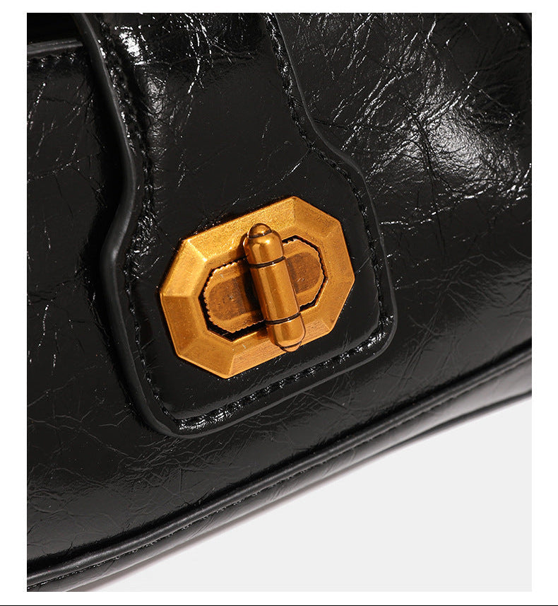 Compact glossy crinkled baguette shoulder bag with amber resin bead strap accent and gold-tone turn-lock closure, detail view