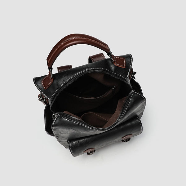 Structured black leather-look convertible backpack handbag with brown contrast trim, buckle front pocket, double-zip top