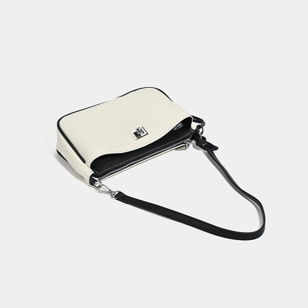 Small structured cream crossbody bag with contrast leather-look trim, silver-tone turn-lock hardware, and adjustable
