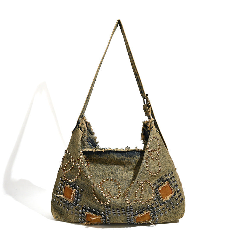 Large distressed denim hobo shoulder bag with mixed-metal rivet detailing and tan leather-look corner trim, detail view 5