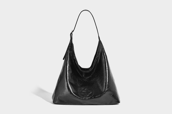 Glossy slouchy hobo shoulder bag with adjustable strap and embossed floral emblem, detail view 10