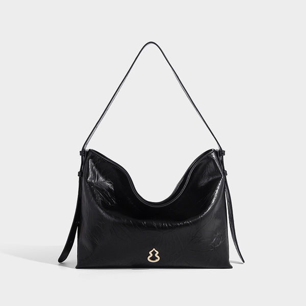Large slouchy hobo shoulder bag in glossy crinkle leather-look finish with gold-tone emblem hardware and adjustable strap