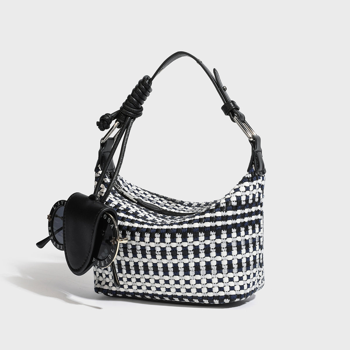 Kleine, sichelförmige Schultertasche aus schwarz-weißem Webtextil mit glattem schwarzem Kunstlederbesatz, Reißverschluss oben, geknotetem