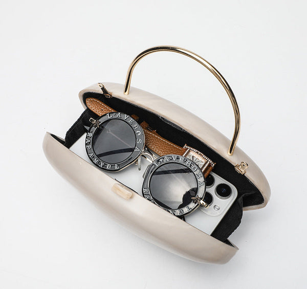 Shell-shaped pearlescent top-handle clutch bag with arched gold-tone metal handle and gold chain strap, detail view 4