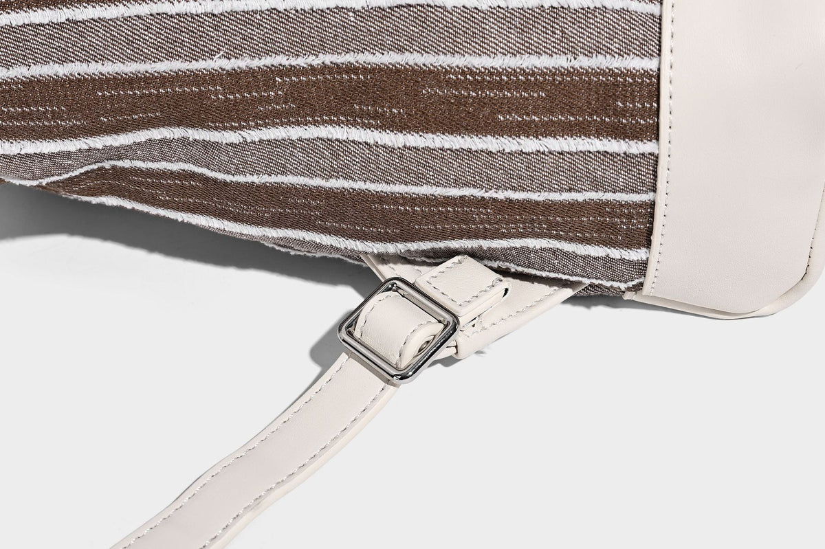 Small structured striped fabric backpack handbag with cream leather-look trim, top handle, and silver-tone hardware, detail