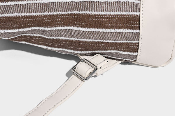 Small structured striped fabric backpack handbag with cream leather-look trim, top handle, and silver-tone hardware, detail
