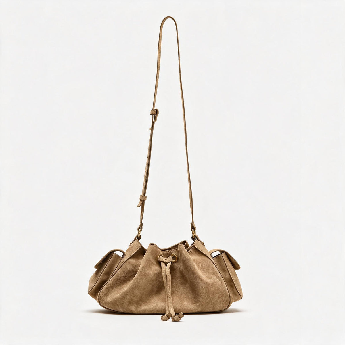 Weiche Beuteltasche mit Kordelzug in Taupe und Wildlederoptik, seitlichen Klappentaschen, antikgoldfarbenen Metalldetails und verstellbarem Crossbody-Riemen