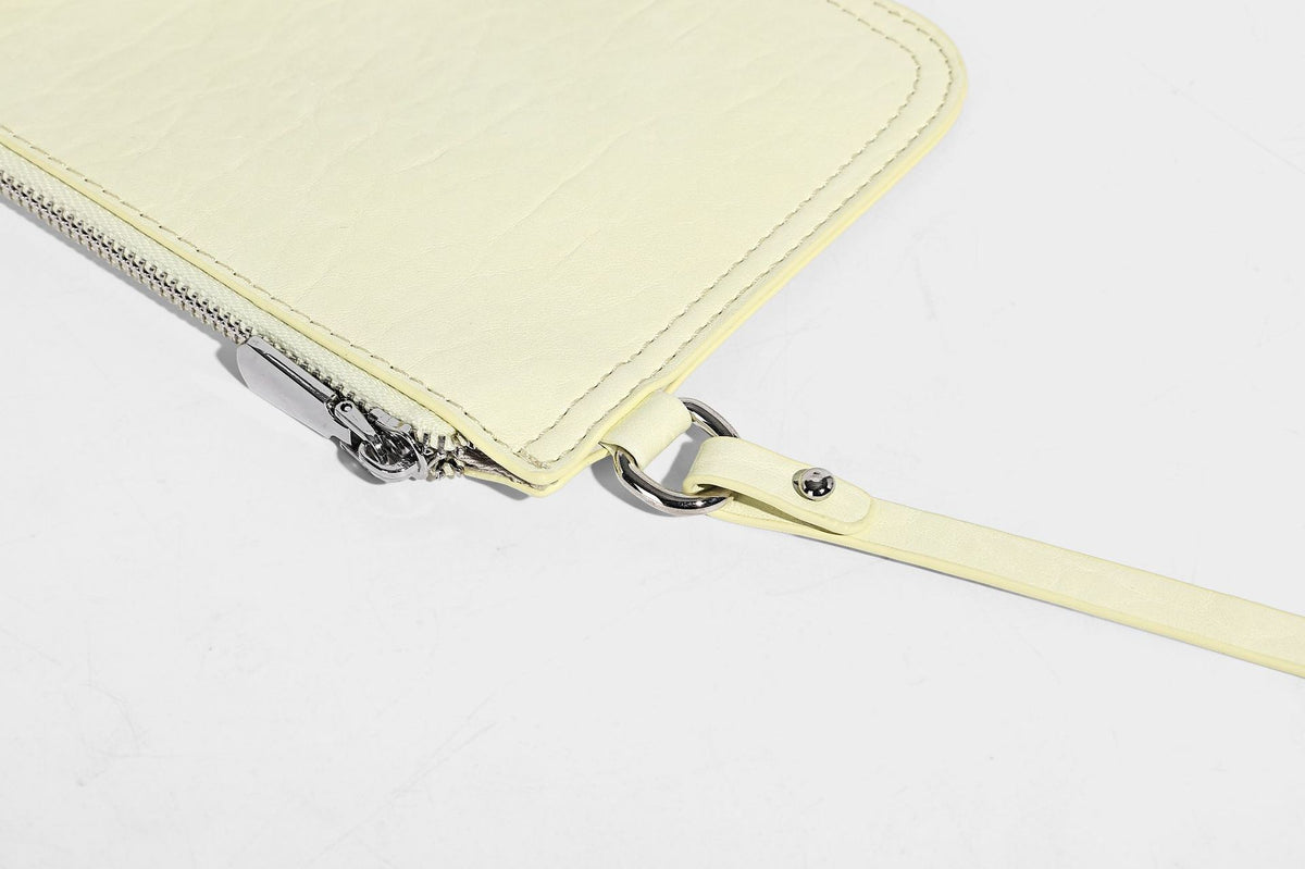 Slouchy hobo shoulder bag in pale yellow glossy pebbled leather-look finish with single shoulder strap and detachable front