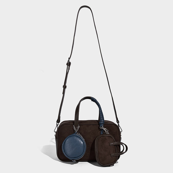 Strukturierte Boston-Bowlingtasche in Veloursleder-Optik, dunkelbraun, mit Henkeln mit blauen Akzenten und abnehmbarem Mini-Rundtäschchen, Detailaufnahme