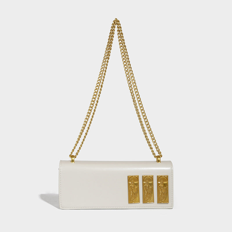 Structured rectangular crossbody bag with glossy finish, three vertical gold-tone embossed plaques, and gold chain strap