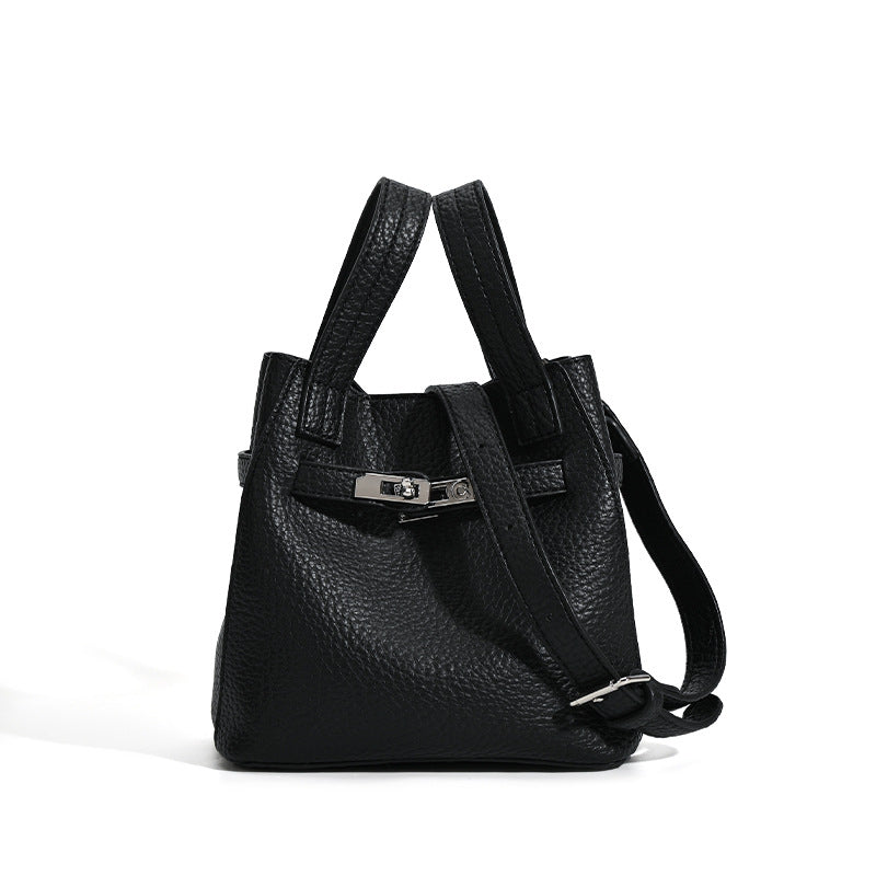 Small structured pebbled leather-look bucket bag with silver turn-lock bar hardware and dual top handles, detail view 5