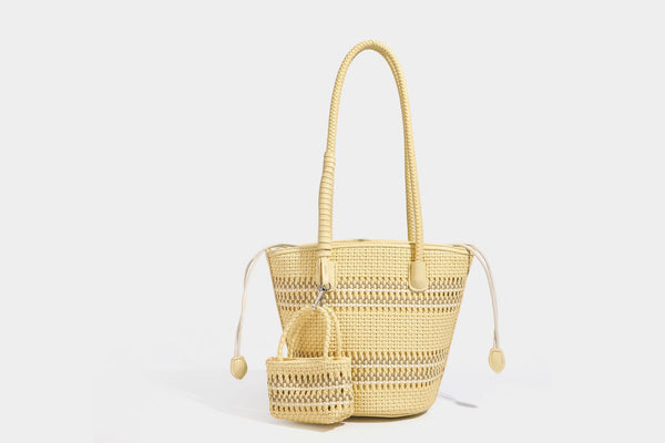 Light blue open-weave woven bucket tote bag with long braided shoulder straps, drawstring side ties, and attached mini pouch