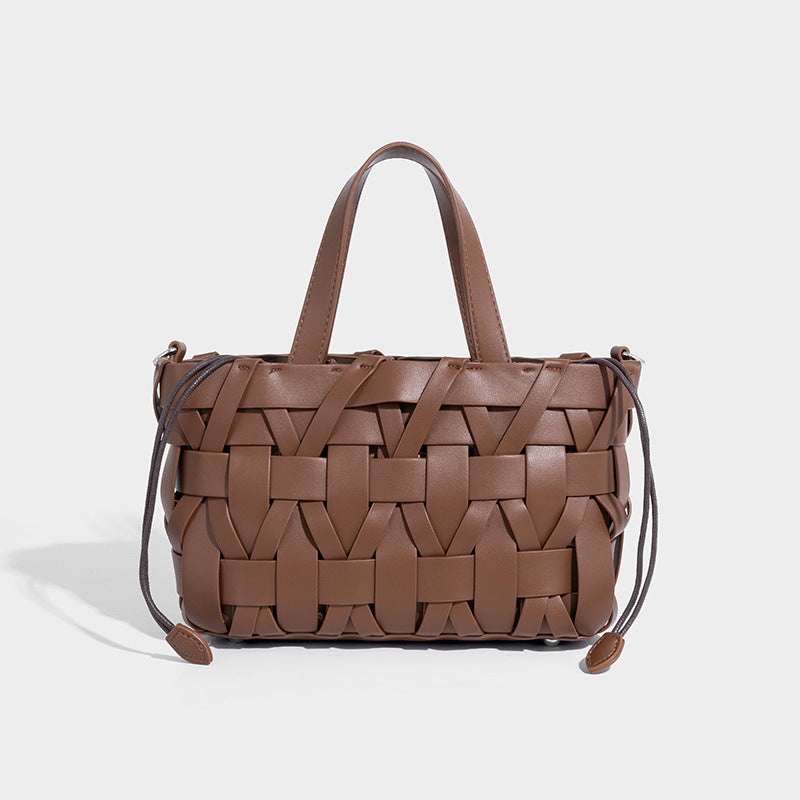 Structured woven basket tote handbag with contrasting dark trim, double top handles, detachable shoulder strap, and