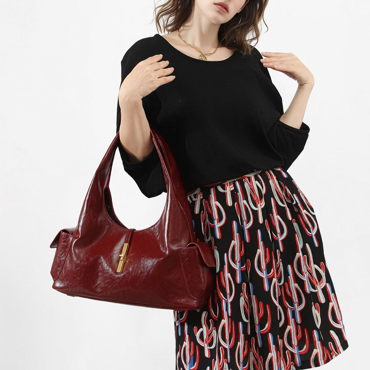 Slouchy leather-look hobo shoulder bag with gold-tone bar clasp and crinkled glossy finish, detail view 3