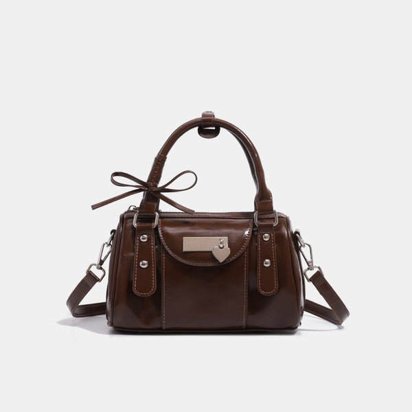 Kleine strukturierte Henkeltasche mit glänzender Oberfläche, zwei Tragegriffen, aufgesetzter Fronttasche, herzförmigem Verschlussanhänger und silberfarbenem