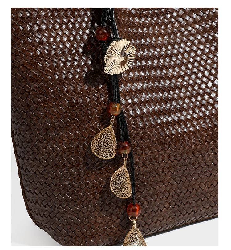Large open-top woven leather-look tote bag in dark brown with scalloped edge, braided double shoulder straps, and decorative