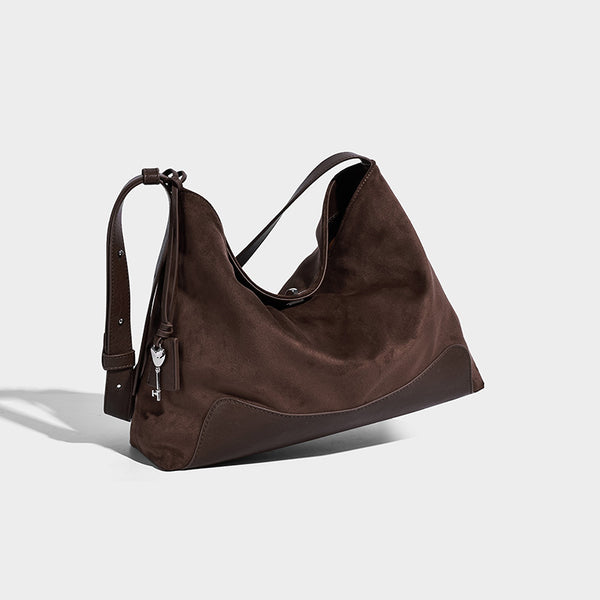 Dark brown slouchy hobo bag with matte suede-look body, smooth leather-look base trim, adjustable shoulder strap, and, detail