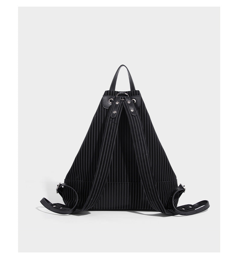 Schwarze wandelbare Rucksack-Handtasche mit Nadelstreifen, Kordelzugverschluss, Tragegriff aus Lederimitat und matten Metallbeschlägen, Detailansicht