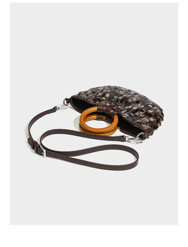 Small sequin half-moon handbag with circular wood-look ring handles and detachable leather-look shoulder strap, detail view