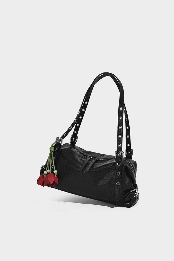Pale yellow leather-look barrel bag with silver grommet-studded shoulder straps, top zip closure, and pink tulip floral