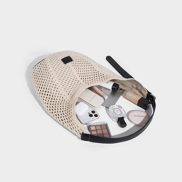 Cream openwork crochet hobo bag with black leather-look strap and trim patch accent, slouchy teardrop silhouette, detail view