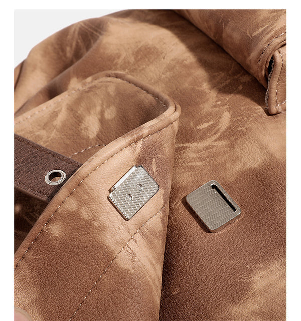 Compact distressed leather-look tan-brown backpack handbag with flap-and-buckle closure, two front patch pockets, top handle