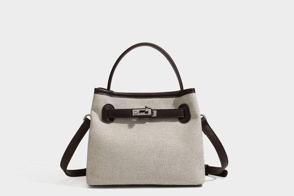 Small structured beige canvas top-handle bag with dark brown leather-look trim, silver turn-lock hardware, and detachable