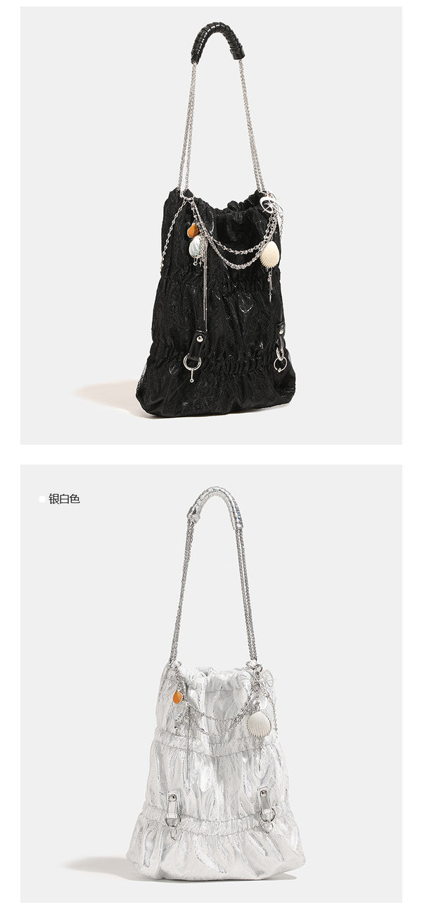 Slouchy lace-texture bucket bag with silver-tone chain strap, draped chain hardware, and shell charms, detail view 10