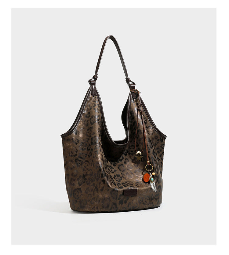 Large slouchy leopard-print shoulder tote bag with glossy tan-and-brown finish, dark brown leather-look trim, single