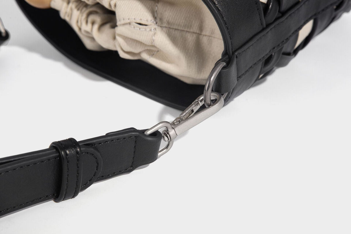 Small cylindrical woven lattice bucket bag with leather-look black trim, beige canvas body, wooden bead drawstring closure