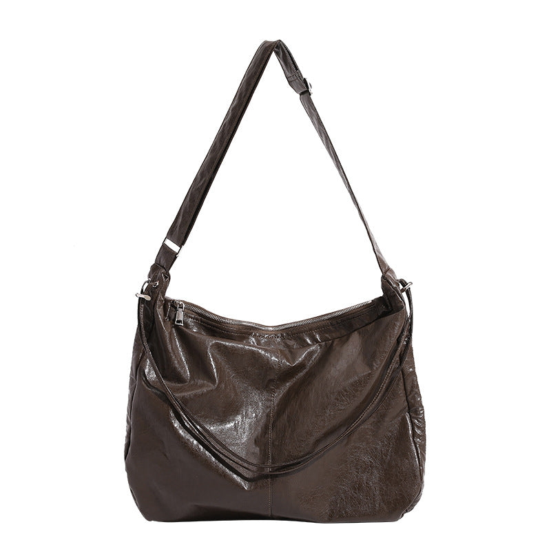 Oversized slouchy hobo shoulder bag with glossy crinkled leather-look finish, drawstring gathered sides, and silver-tone