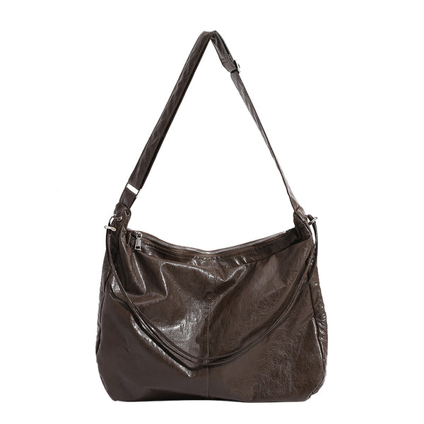 Oversized slouchy hobo shoulder bag with glossy crinkled leather-look finish, drawstring gathered sides, and silver-tone
