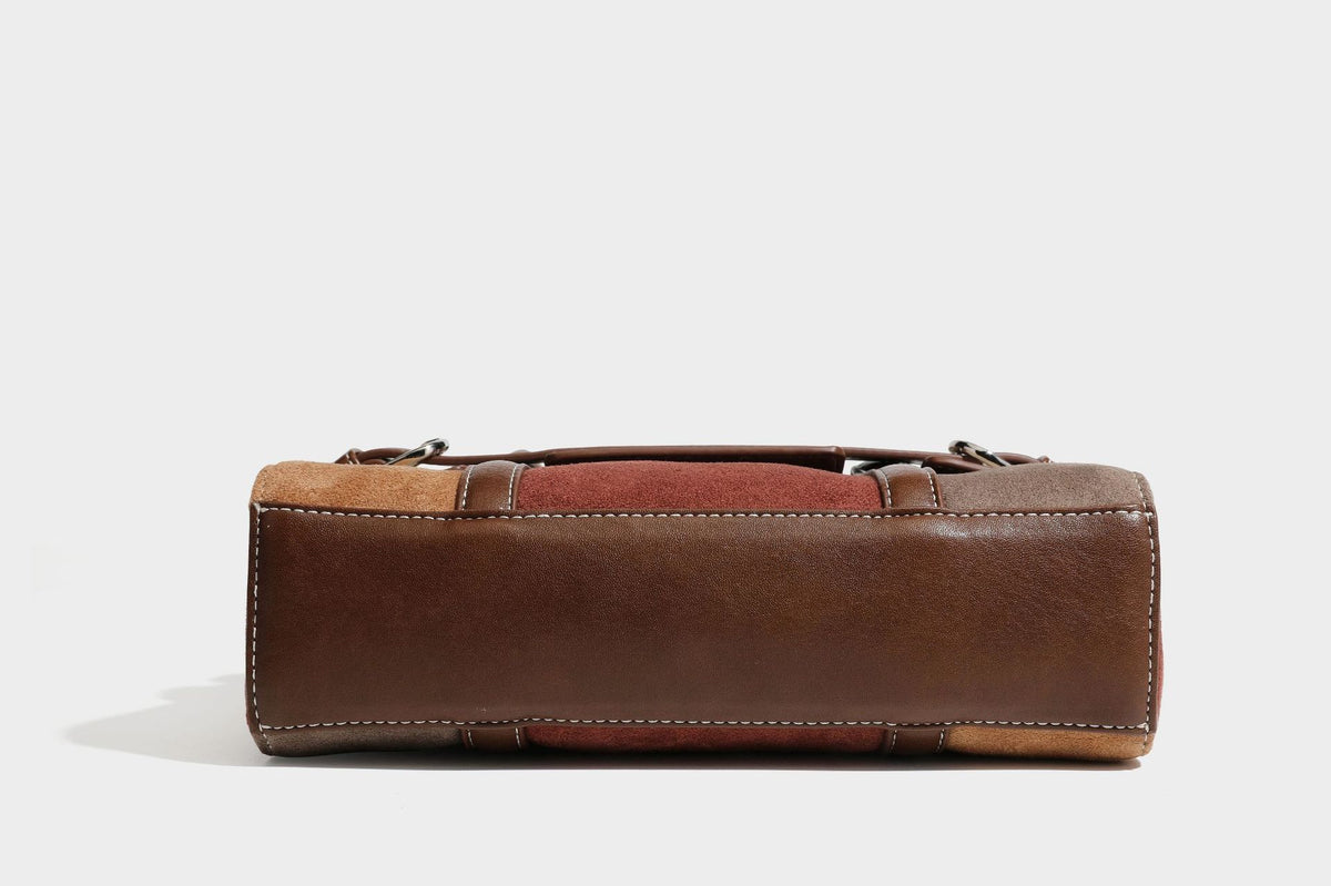 Structured color-block satchel bag in brown, rust, beige, and taupe suede-look panels with white topstitching, front buckle