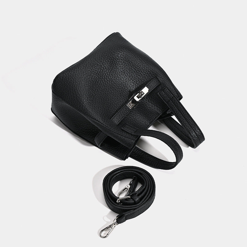 Small structured pebbled leather-look bucket bag with silver turn-lock bar hardware and dual top handles, detail view 4